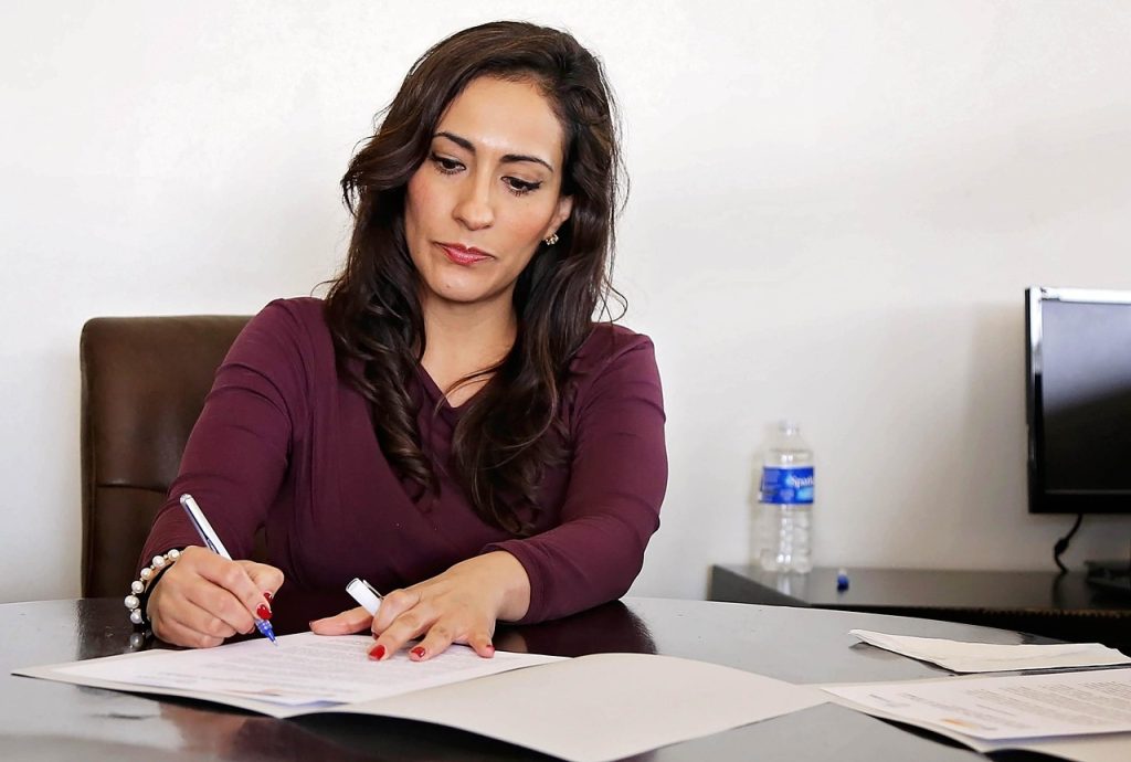 Mulher analisando documentos em uma mesa de escritório